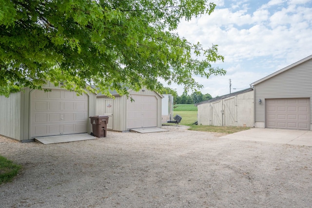 view of yard featuring a garage and an outbuilding