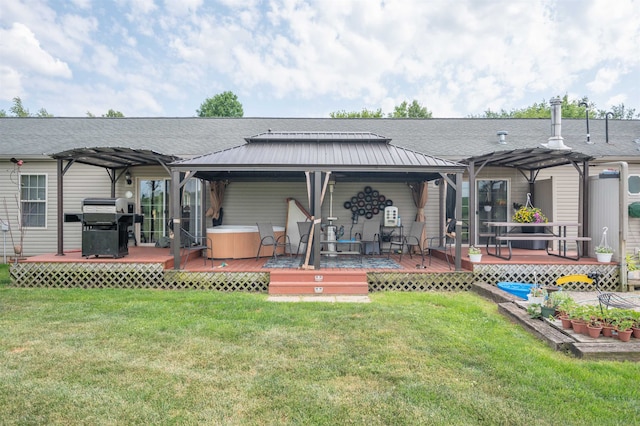 rear view of property with a yard, a pergola, a hot tub, and a wooden deck