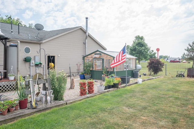 back of property with an outdoor structure and a yard