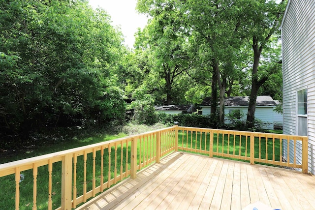 wooden terrace featuring a lawn