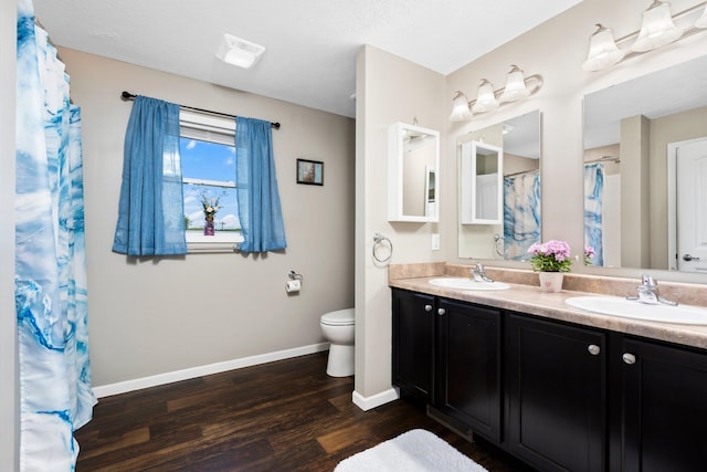 bathroom featuring a textured ceiling, vanity, hardwood / wood-style flooring, and toilet