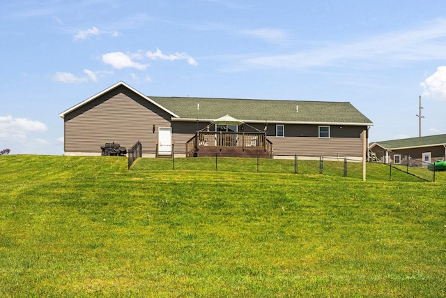 back of property with a lawn and a deck