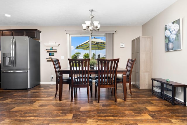 dining room with dark hardwood / wood-style flooring and a notable chandelier