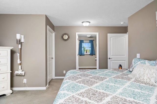 bedroom with a textured ceiling and light colored carpet