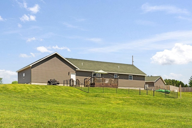 back of house featuring a lawn and a deck