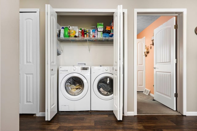 laundry room with a textured ceiling, dark hardwood / wood-style flooring, and washing machine and clothes dryer