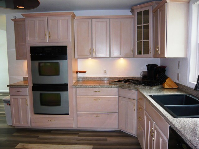 kitchen with light brown cabinets, stainless steel double oven, dark hardwood / wood-style floors, and sink