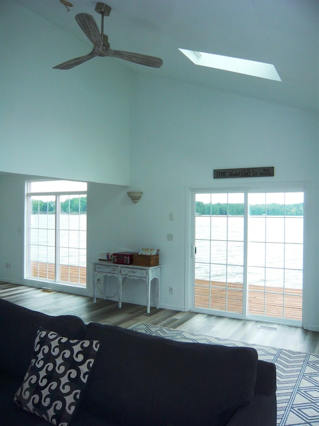 living room with a skylight, plenty of natural light, and light wood-type flooring