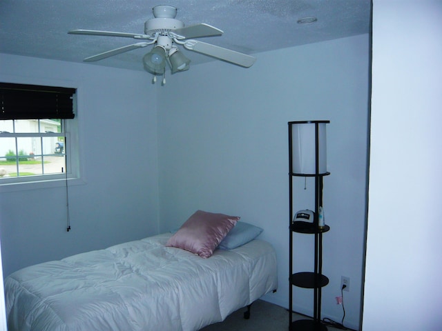 bedroom featuring a textured ceiling, carpet floors, and ceiling fan