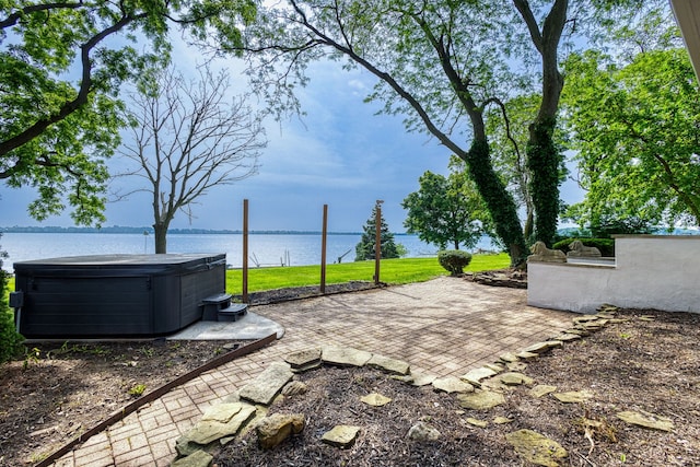 view of yard featuring a water view, a patio, and a hot tub