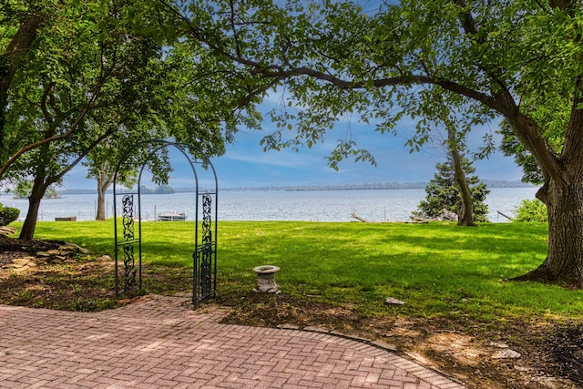 view of property's community with a water view and a yard