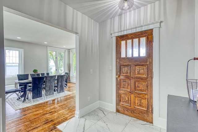 foyer entrance with a wealth of natural light and light hardwood / wood-style flooring