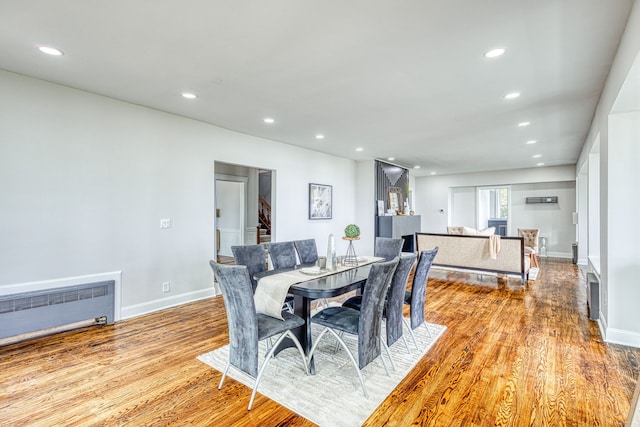 dining area with light wood-type flooring and radiator heating unit