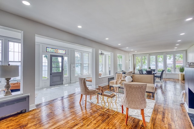 living room featuring a wealth of natural light, radiator heating unit, and light hardwood / wood-style flooring