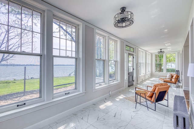 sunroom / solarium featuring a water view