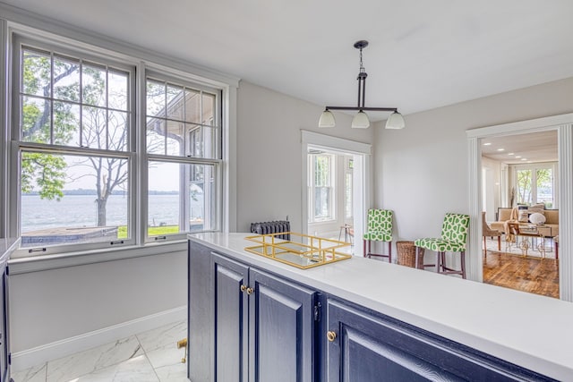 kitchen featuring pendant lighting, a water view, and plenty of natural light