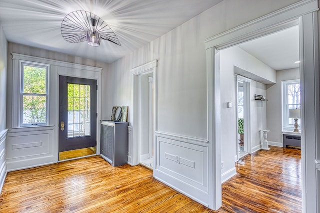 foyer entrance with light wood-type flooring and radiator heating unit