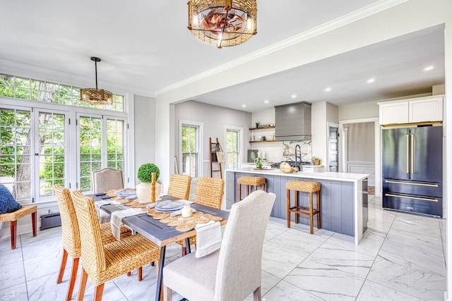 dining room with a wealth of natural light, sink, a baseboard radiator, and ornamental molding