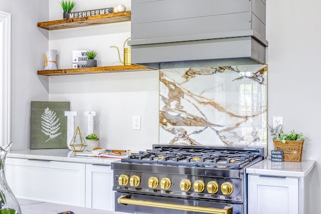 bar featuring black range with gas stovetop and white cabinetry