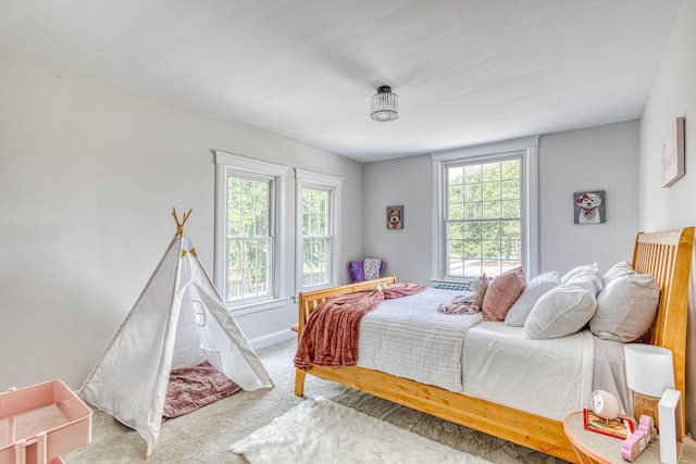 carpeted bedroom featuring multiple windows