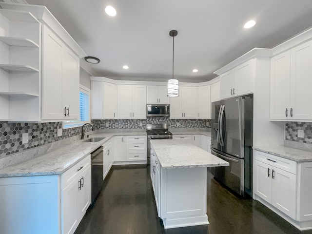 kitchen featuring stainless steel appliances, sink, white cabinets, a center island, and hanging light fixtures