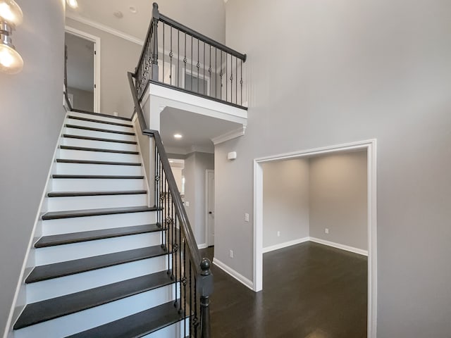 stairs featuring a high ceiling and ornamental molding