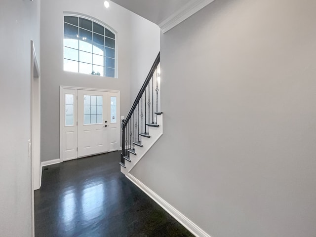 entrance foyer with a high ceiling, dark hardwood / wood-style floors, and ornamental molding