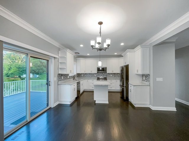 kitchen with appliances with stainless steel finishes, a center island, decorative light fixtures, and white cabinetry