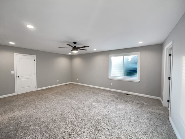 carpeted spare room featuring ceiling fan