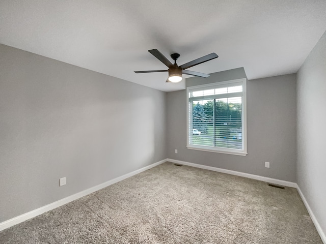 carpeted spare room with ceiling fan