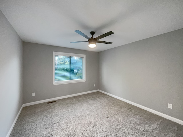 carpeted spare room featuring ceiling fan