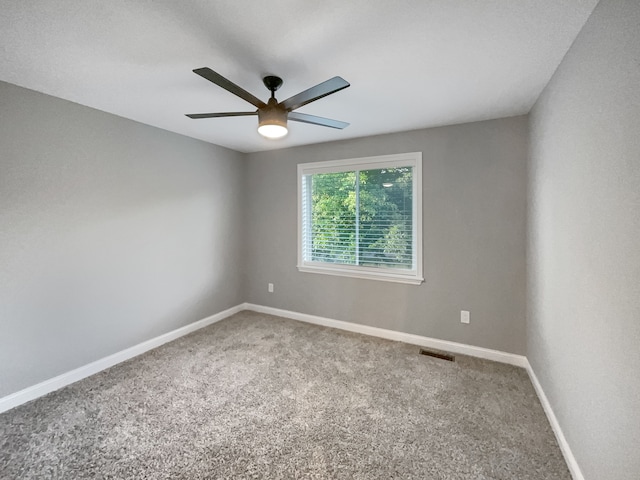 carpeted spare room with ceiling fan