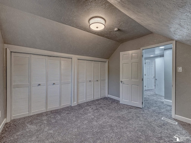 additional living space with a textured ceiling, carpet floors, and lofted ceiling