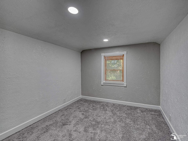 empty room with carpet floors and a textured ceiling