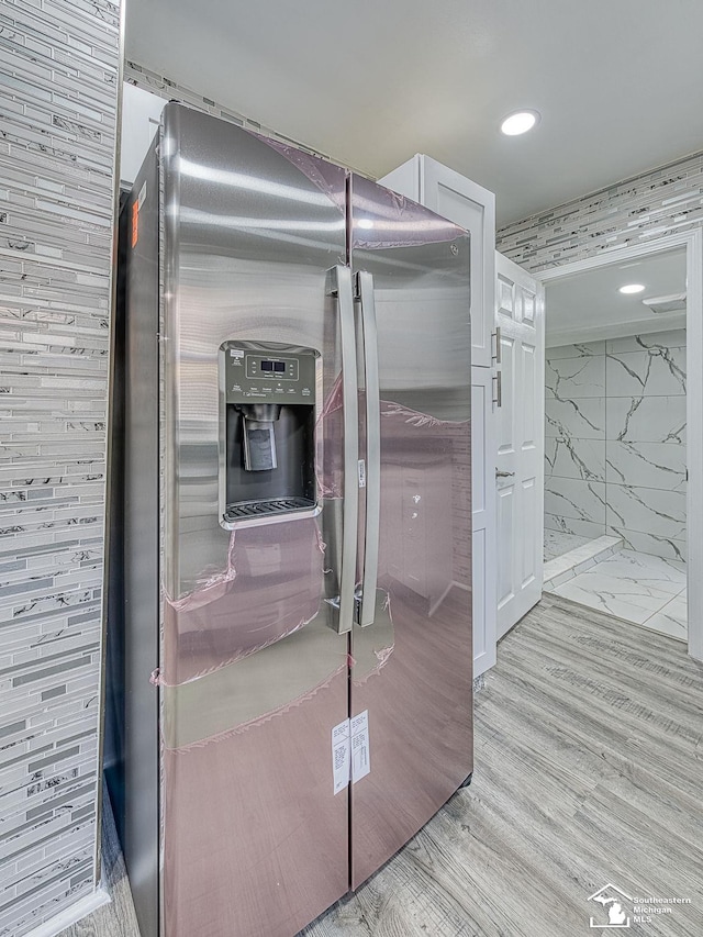 interior space featuring light wood-type flooring and stainless steel fridge with ice dispenser