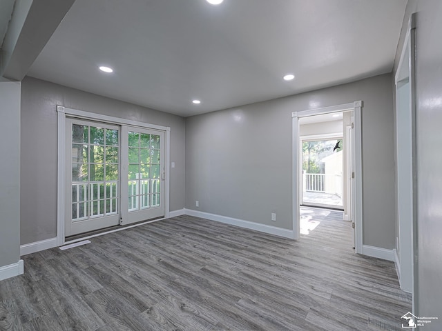 spare room featuring a wealth of natural light and hardwood / wood-style floors