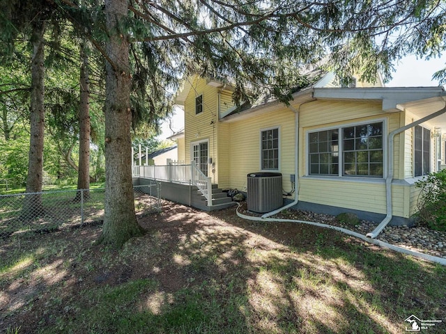 view of property exterior with cooling unit and a deck