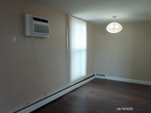 unfurnished room with baseboards, a notable chandelier, an AC wall unit, a baseboard radiator, and wood finished floors
