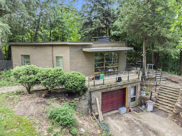 6888 Ann Arbor Rd, Jackson, MI 49201 - view of front of property with a balcony, a garage, stucco siding, and driveway