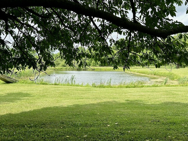 view of property's community featuring a lawn and a water view