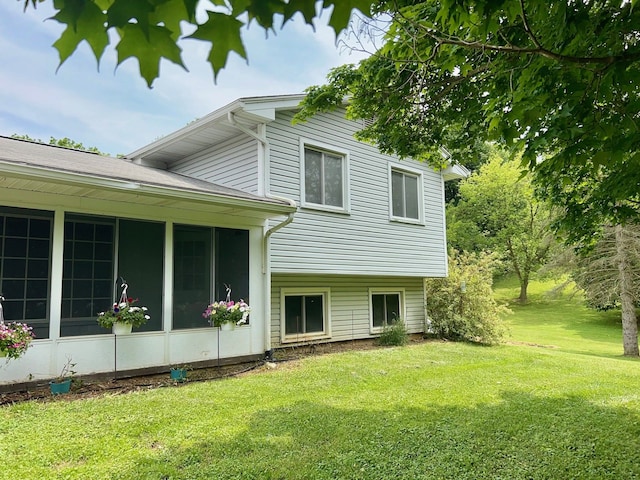 view of property exterior featuring a sunroom and a yard