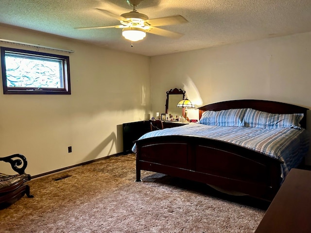 carpeted bedroom with ceiling fan and a textured ceiling