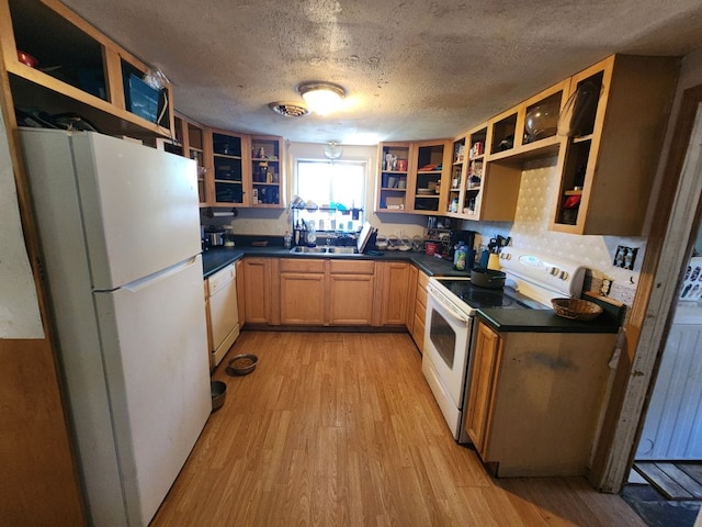 kitchen with backsplash, a textured ceiling, white appliances, sink, and light hardwood / wood-style floors