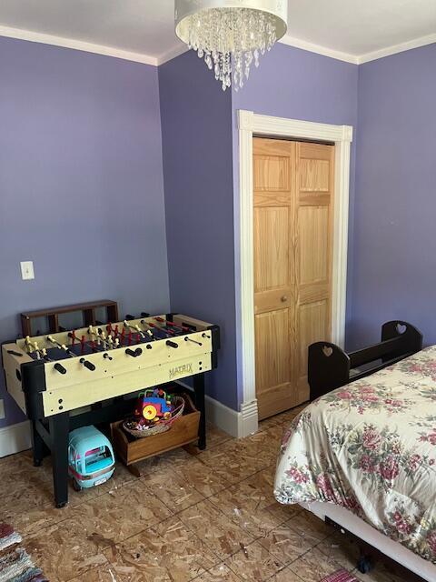 423 Oak St, Paw Paw, MI 49079 - bedroom with crown molding, baseboards, and a chandelier