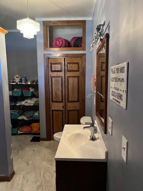 423 Oak St, Paw Paw, MI 49079 - bathroom with vanity, a chandelier, toilet, and marble finish flooring
