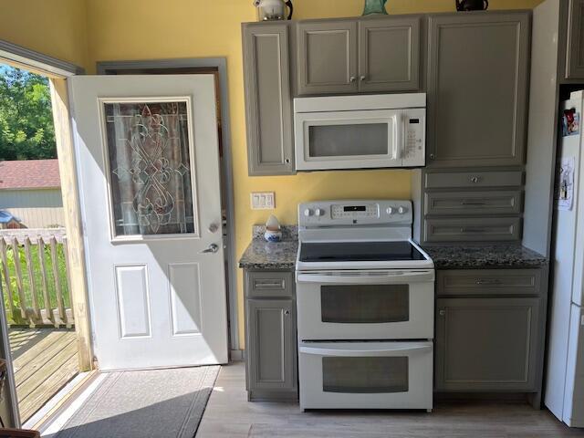 423 Oak St, Paw Paw, MI 49079 - kitchen featuring white appliances, gray cabinets, dark stone counters, and light wood-style floors