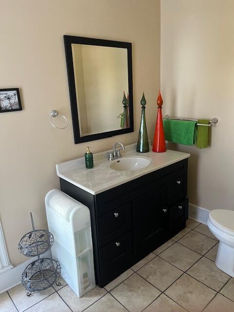 423 Oak St, Paw Paw, MI 49079 - bathroom featuring vanity, toilet, tile patterned floors, and baseboards