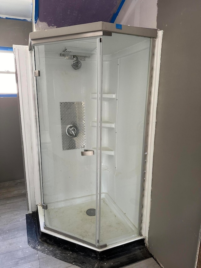 bathroom with an enclosed shower and wood-type flooring