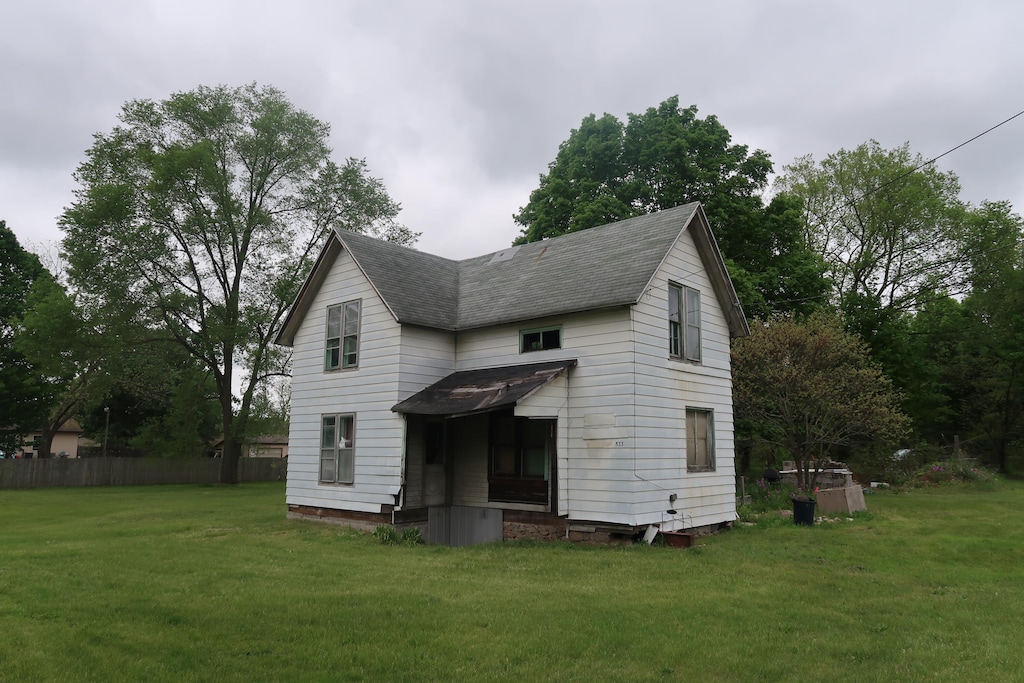 back of property featuring a lawn