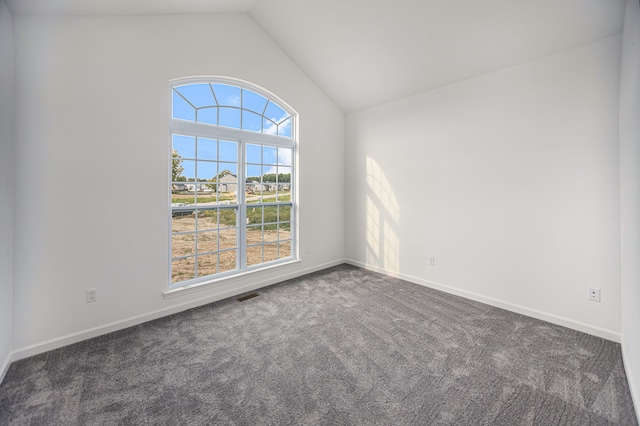 carpeted empty room with lofted ceiling